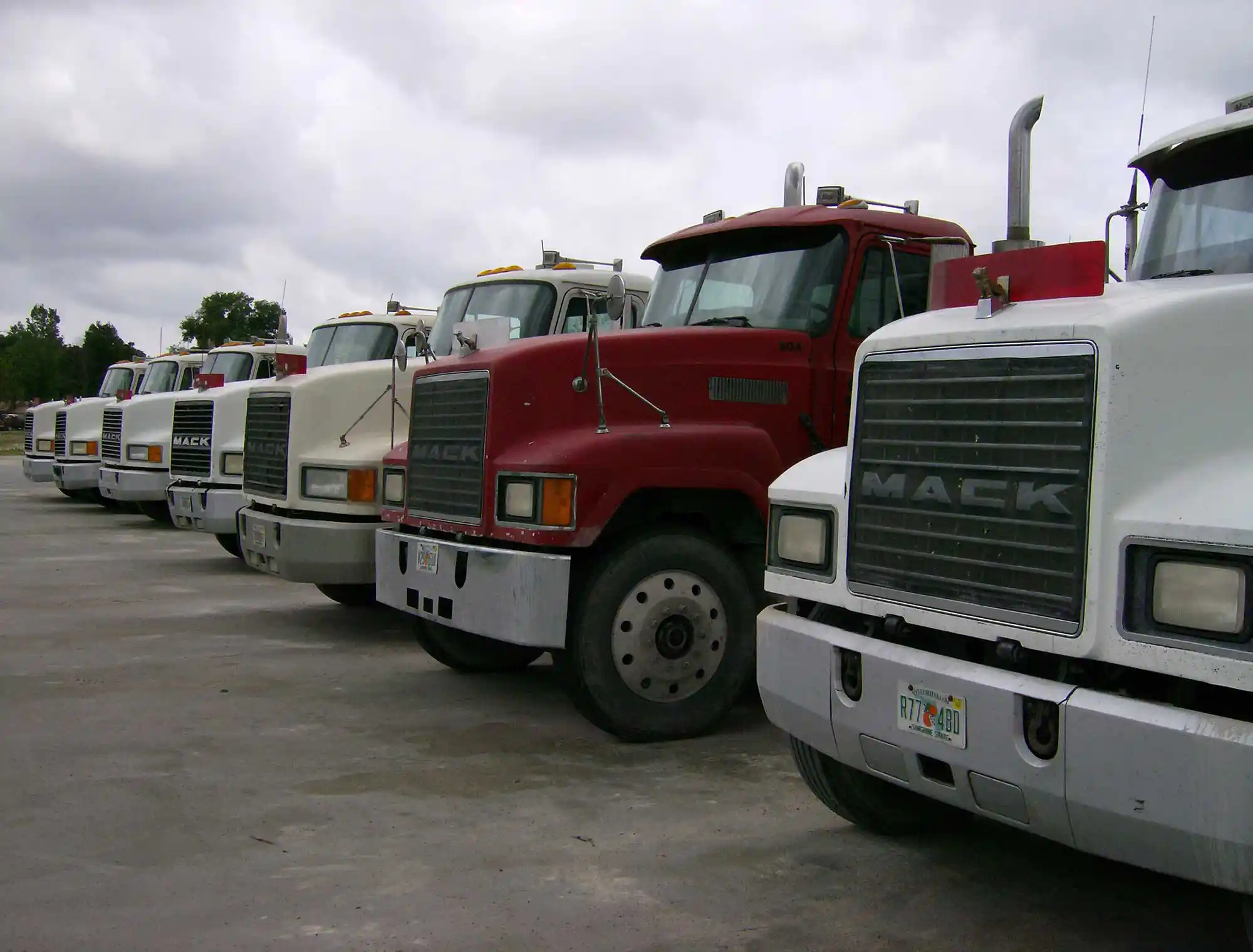 A line of seven tractor/trailer used for hauling large quantities of construction material.
